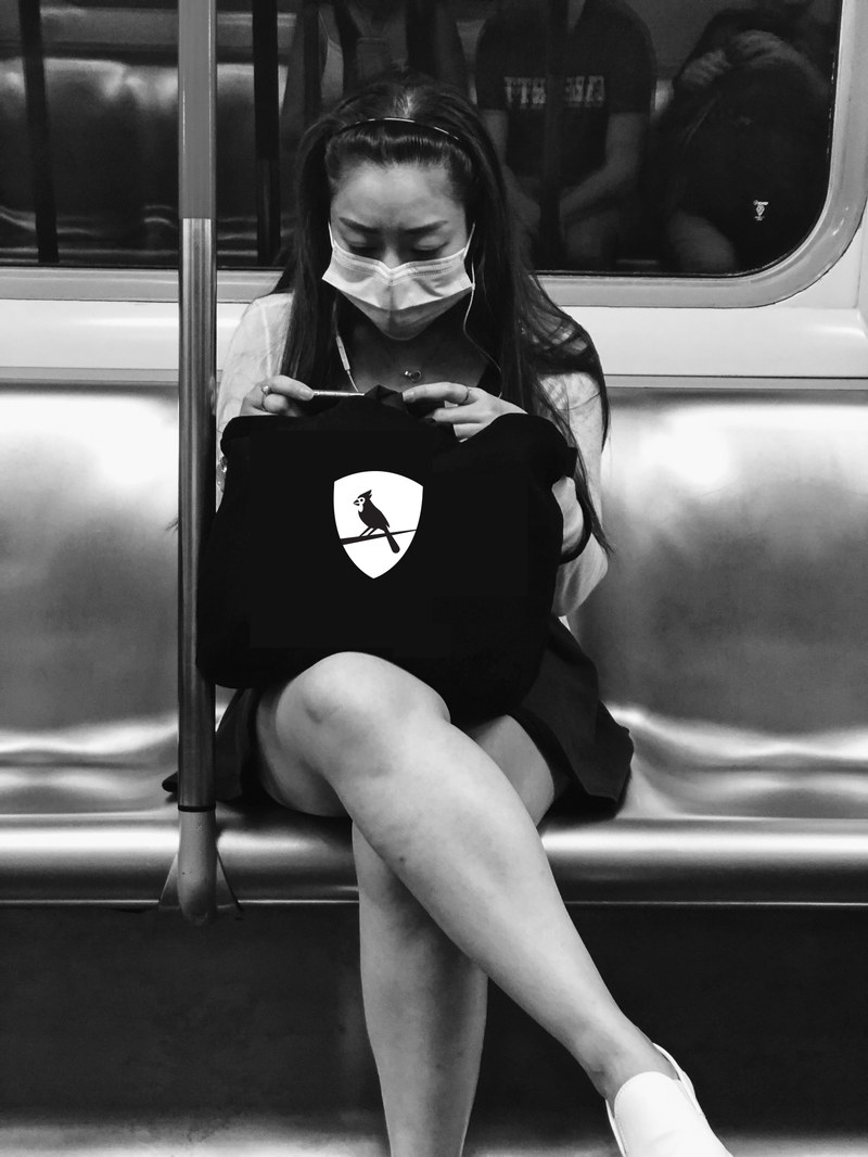 A student sits in a subway cart with a york branded bag