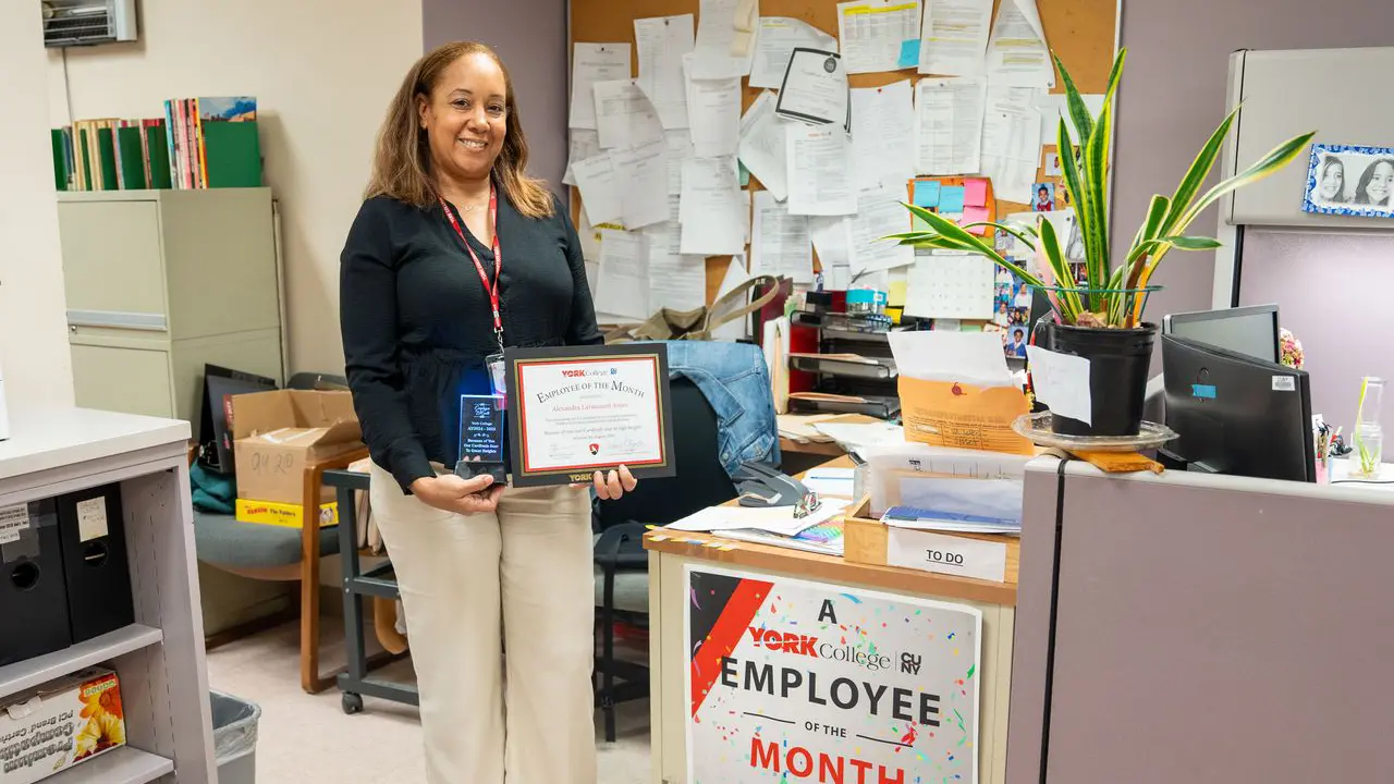 Alexandra Laviscount-Jones shows off her Employee of the Month award in her private office space
