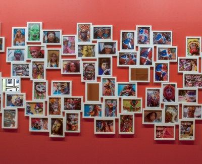 large number of small photographs as installed in a cluster in the gallery, centre portion